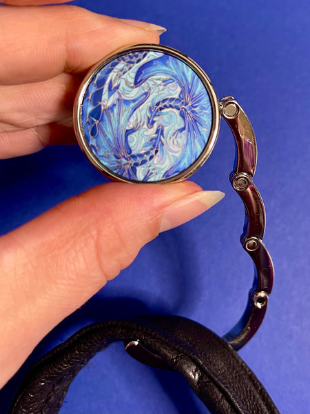 Blue dragon business hand bag hanger, keep in your handbag, unfurl hook to hang you hand bag form cafe or restaurant table. Keeps bag of the dirty floor and safe in your line of vision.